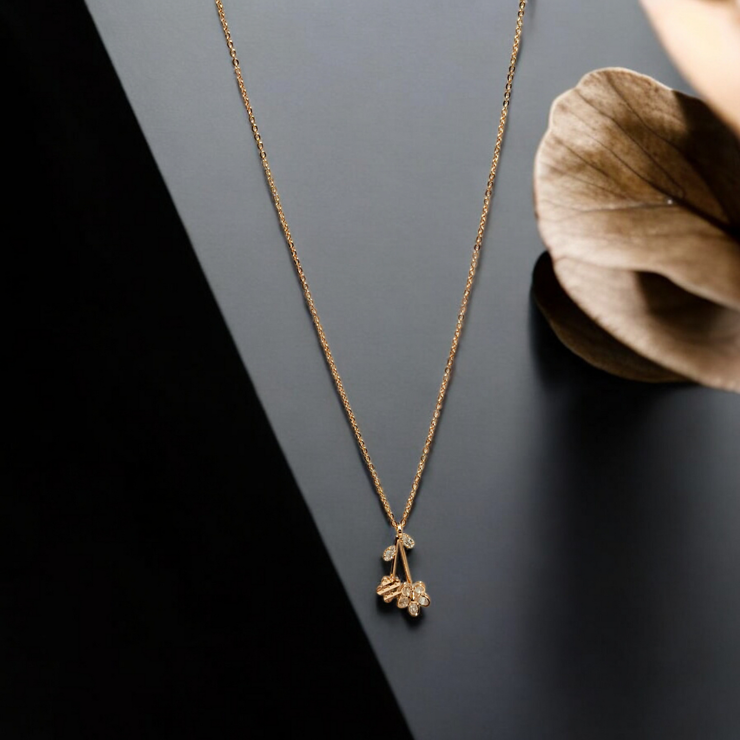 Gold necklace with a floral pendant on a dark surface