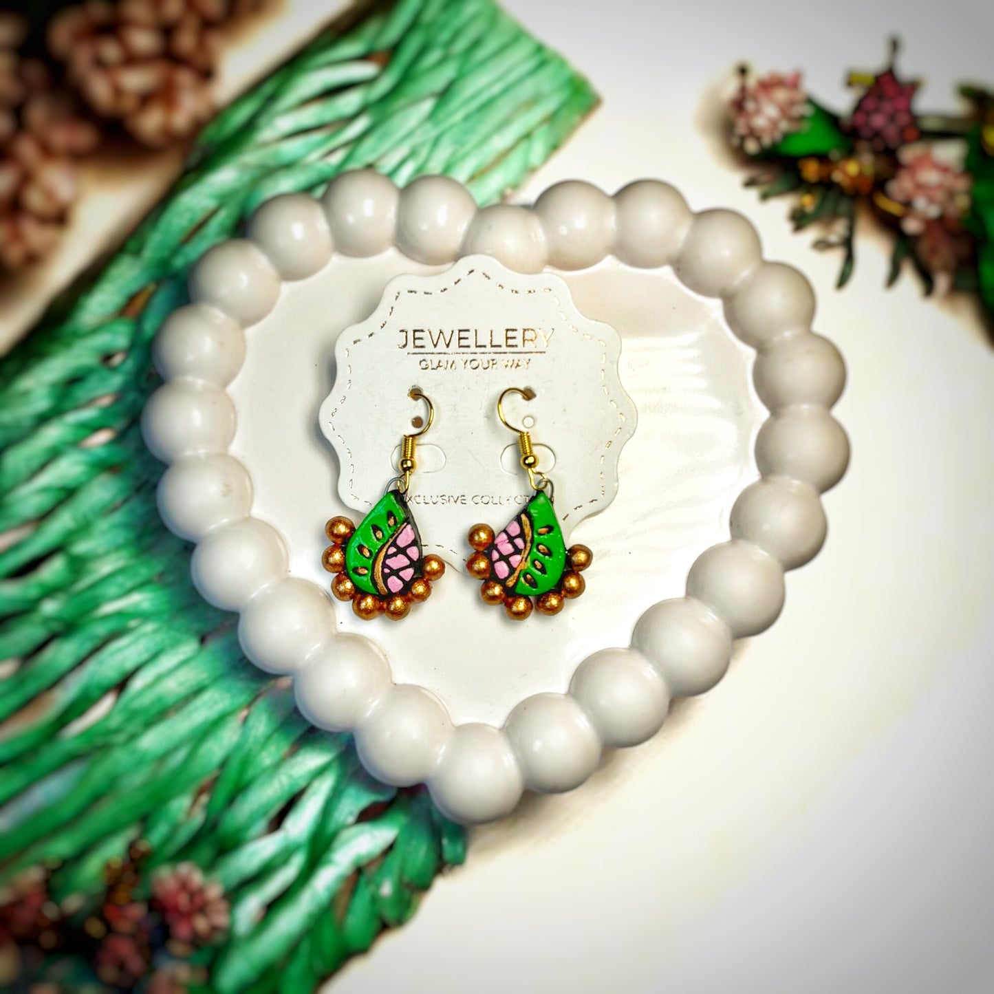 Beautifully Handcrafted Terracotta Earrings Mrritika with green and pink leaf design and golden bead accents