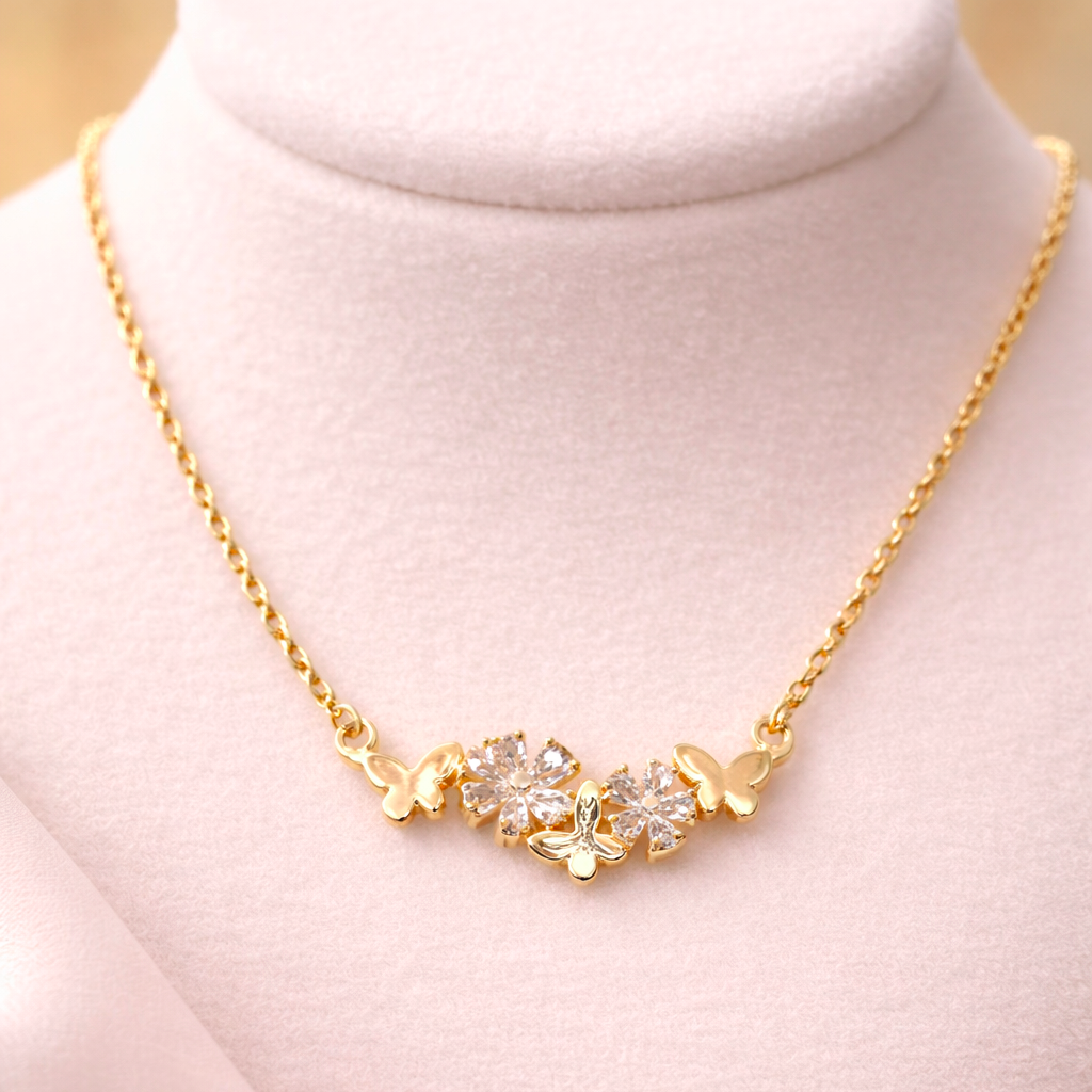 Gold necklace with floral design on a mannequin bust against a light pink background
