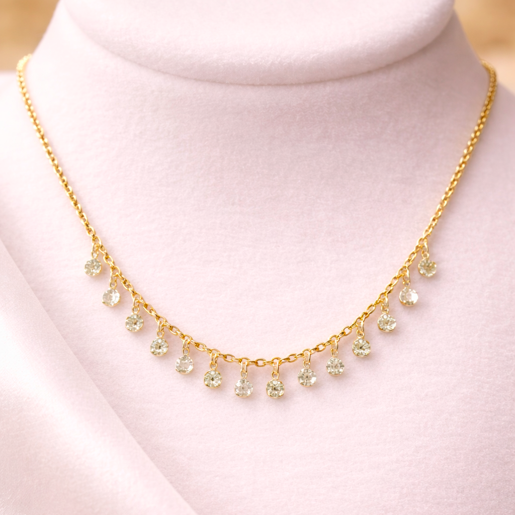 Gold necklace with small green beads on a white mannequin bust
