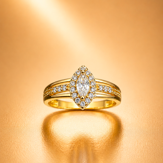 A yellow gold ring featuring a marquise-cut diamond center stone surrounded by a diamond halo, with smaller diamonds set along the band, displayed on a warm, reflective gold surface.