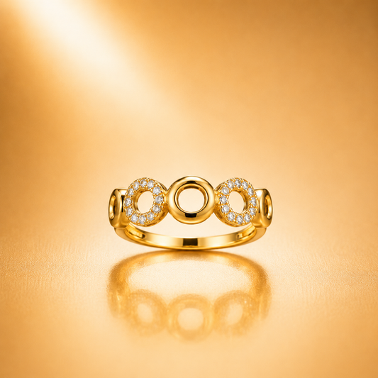A gold ring with three circular openwork motifs, including two pavé-set clear stones, photographed on a warm gold reflective surface.