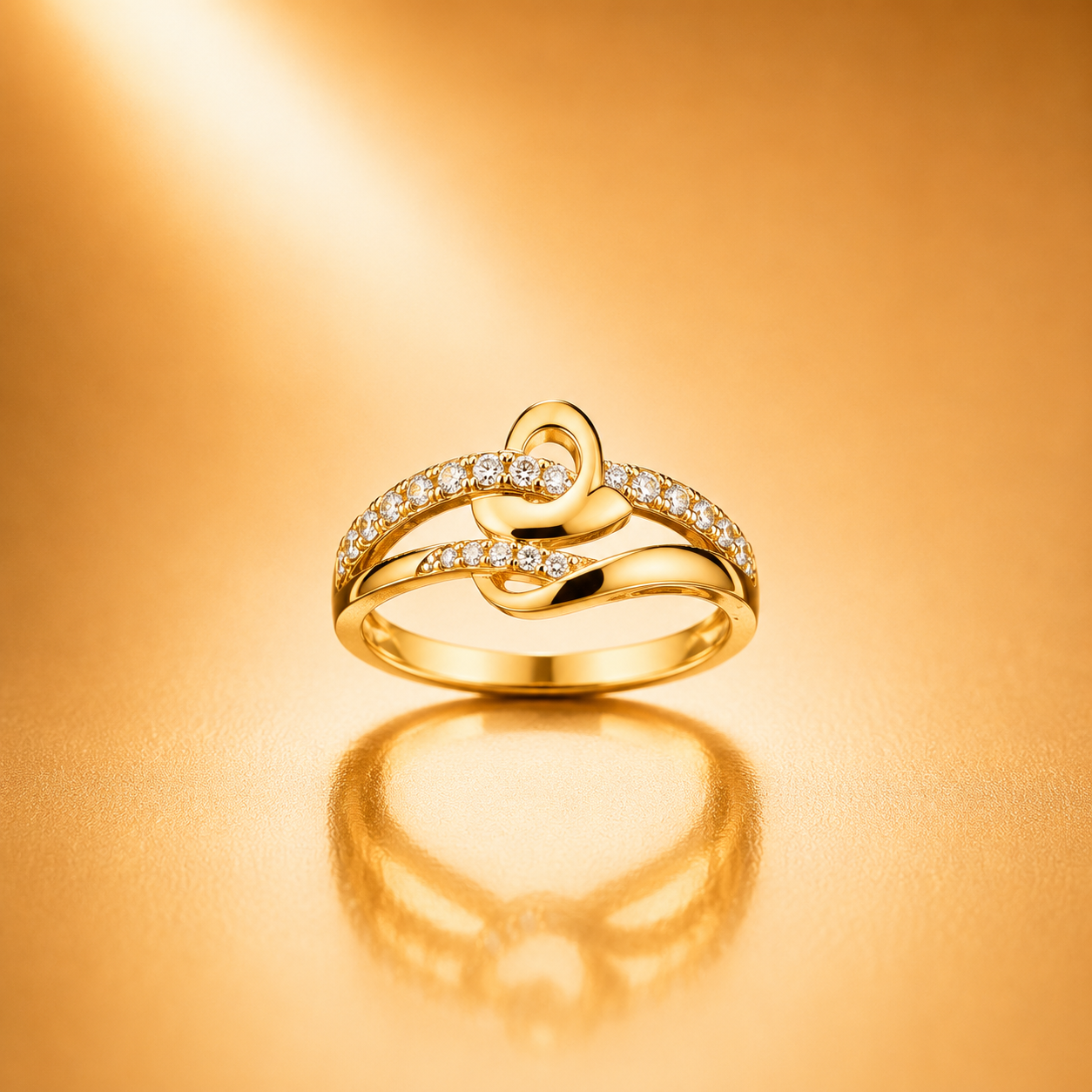 A gold ring with a heart-shaped design and small clear stones, displayed on a warm gold reflective surface.
