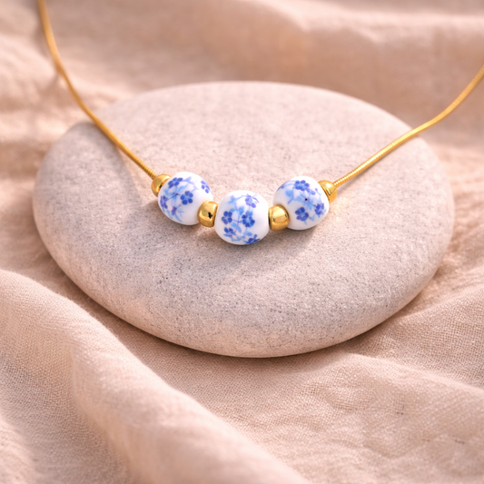 Necklace with blue floral beads on a beige stone