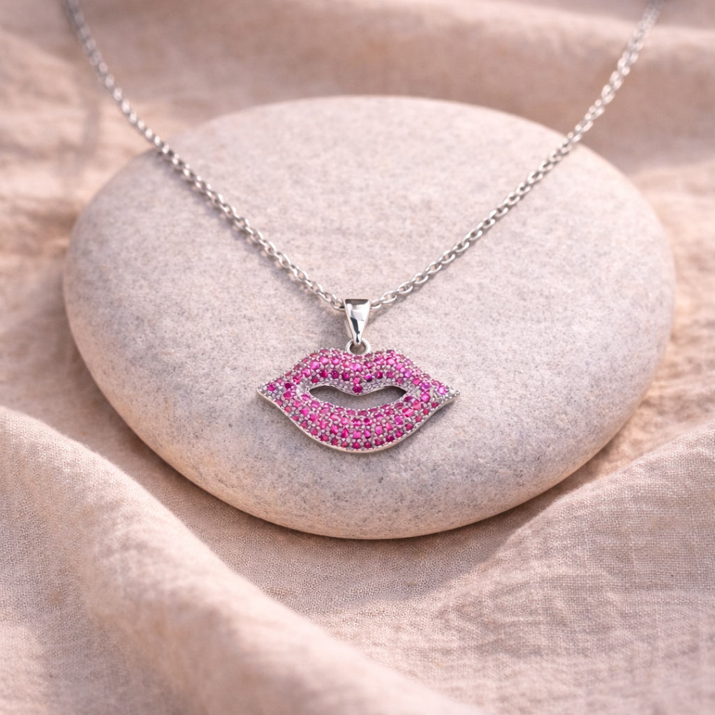 Necklace with a pink lip-shaped pendant on a stone surface