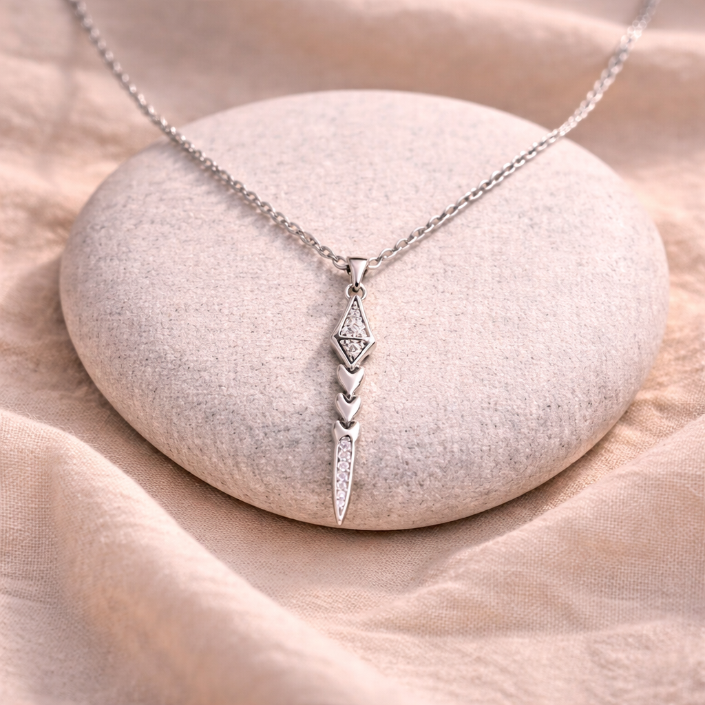 Silver necklace with a pendant on a stone surface