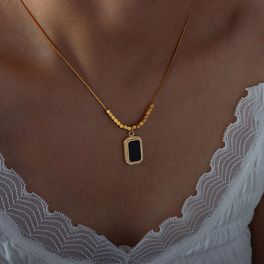 Necklace with a pendant worn by a person, focusing on the necklace against a neutral background.