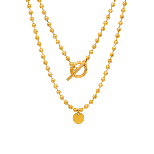 Gold beaded necklace with a toggle clasp on a white background