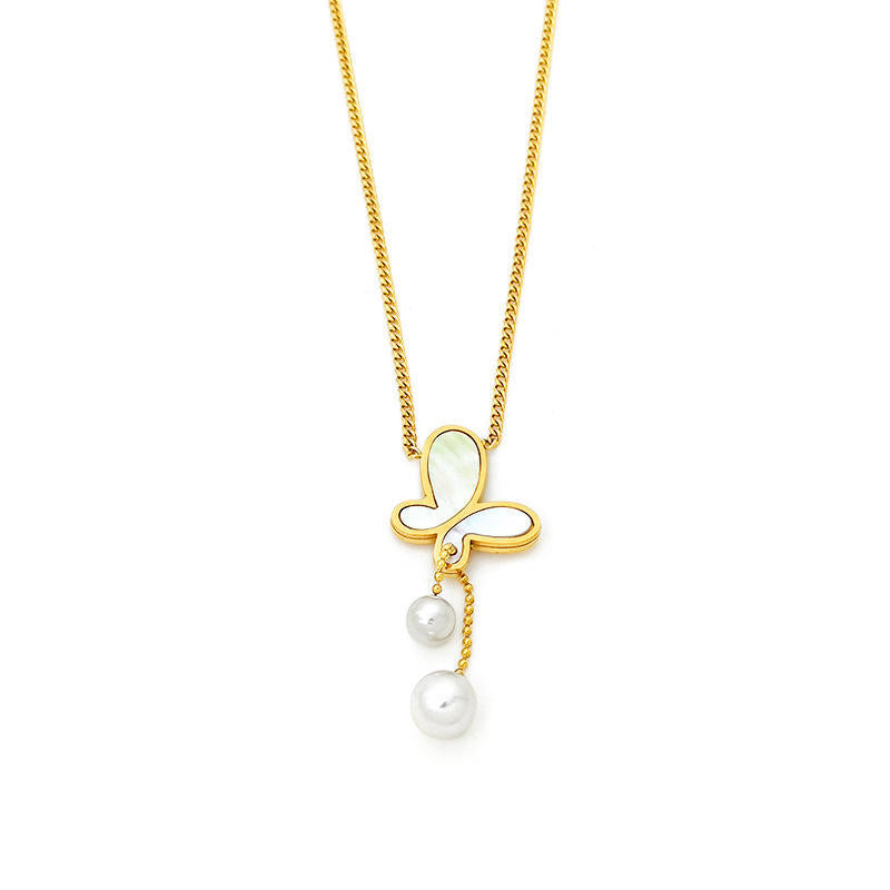Gold necklace with a butterfly pendant and pearl drop on a white background