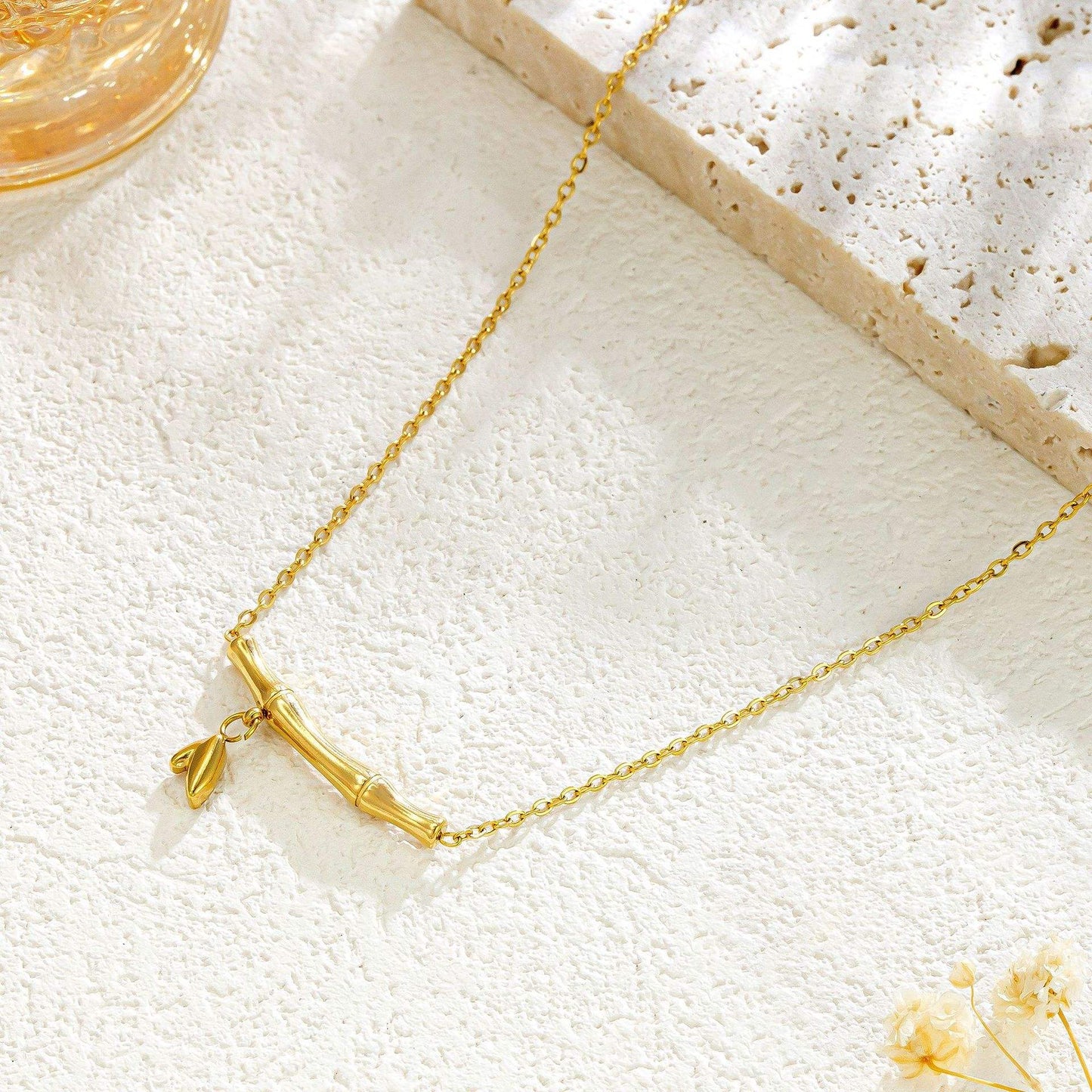 Gold necklace on a textured white surface with a blurred background