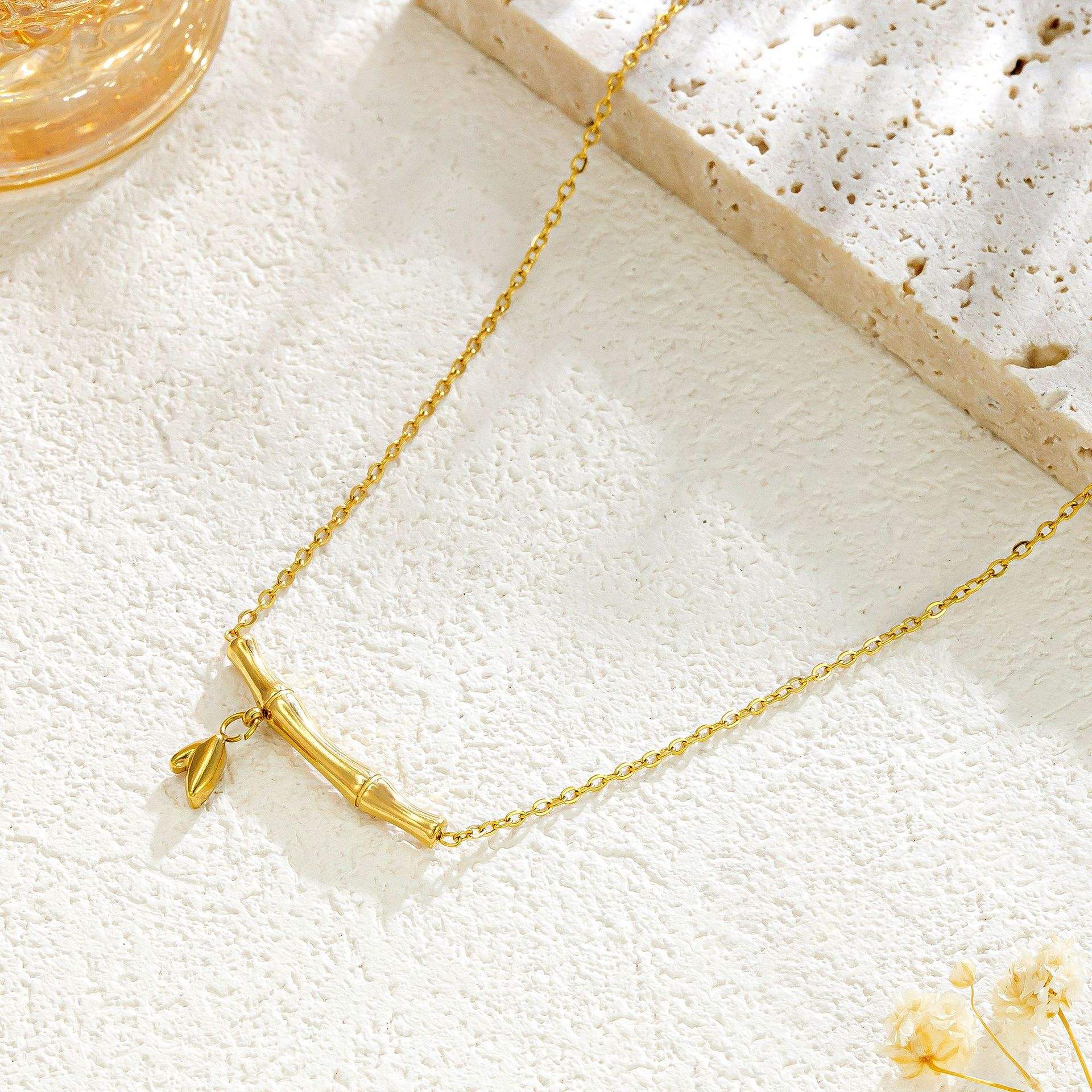 Gold necklace on a textured white surface with a blurred background