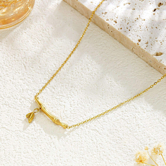 Gold necklace on a textured white surface with a blurred background