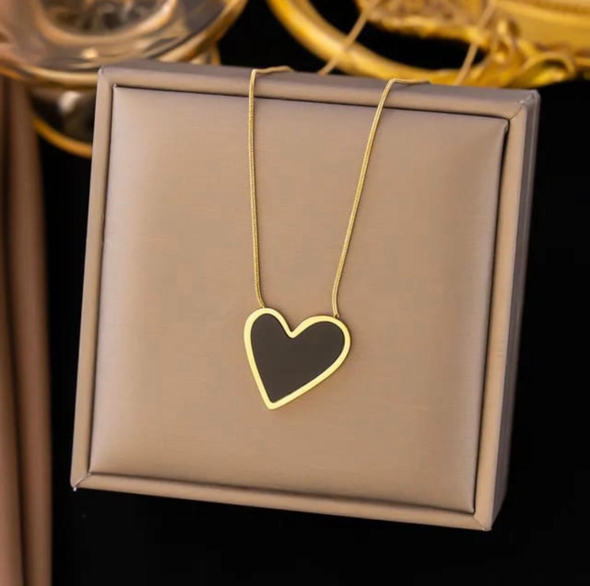 Gold heart-shaped necklace on a brown jewelry box