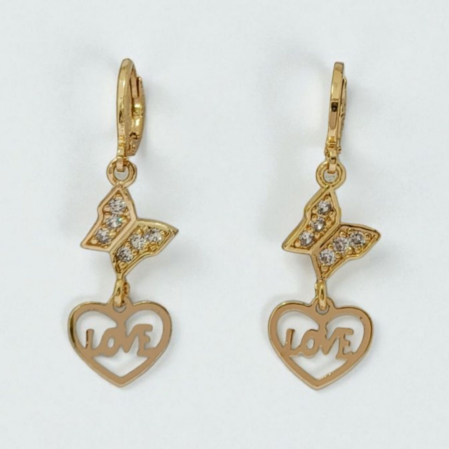 Gold earrings with butterfly and heart designs on a white background