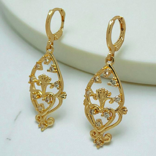 Gold earrings with intricate designs on a white surface