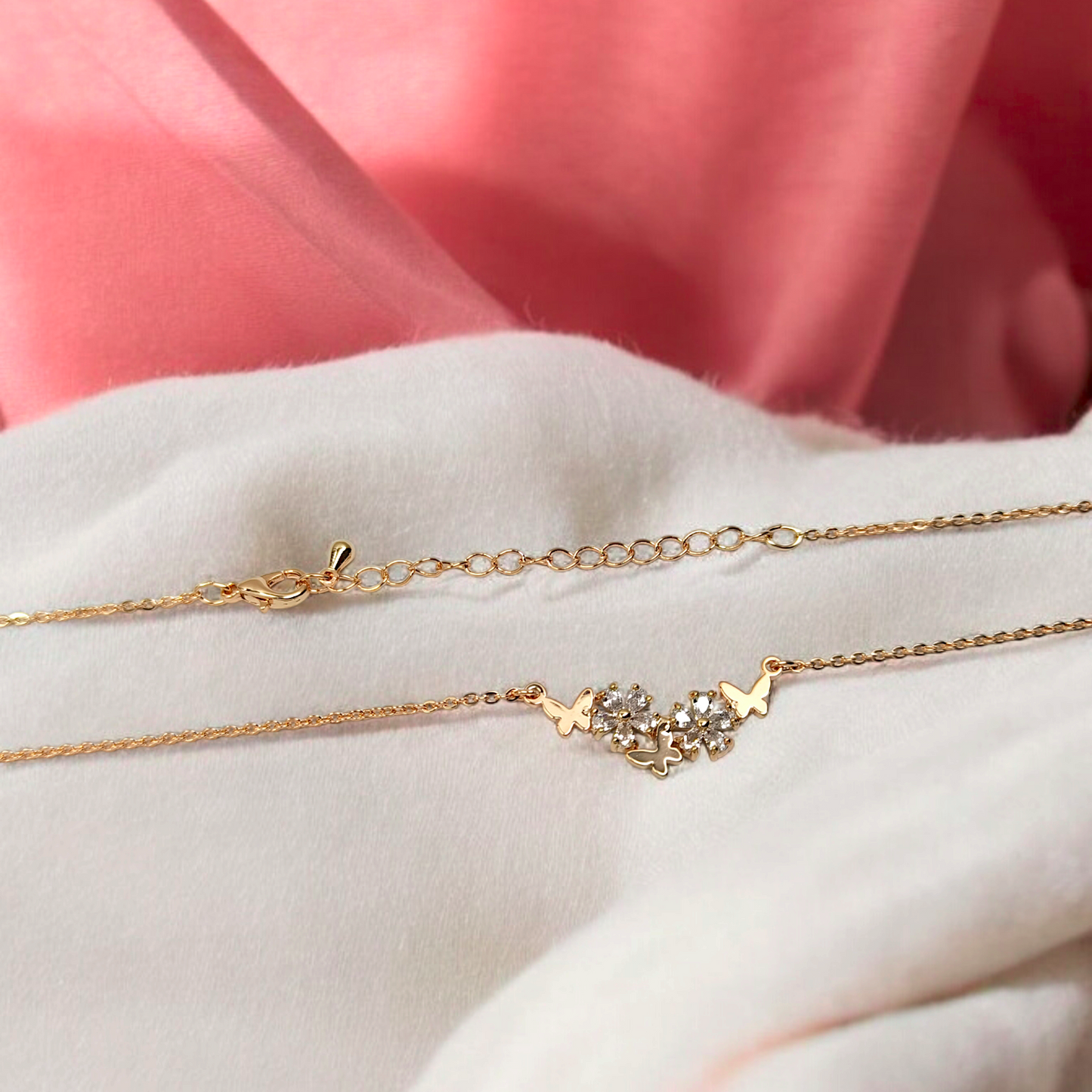 Gold necklace with star and heart design on a white surface