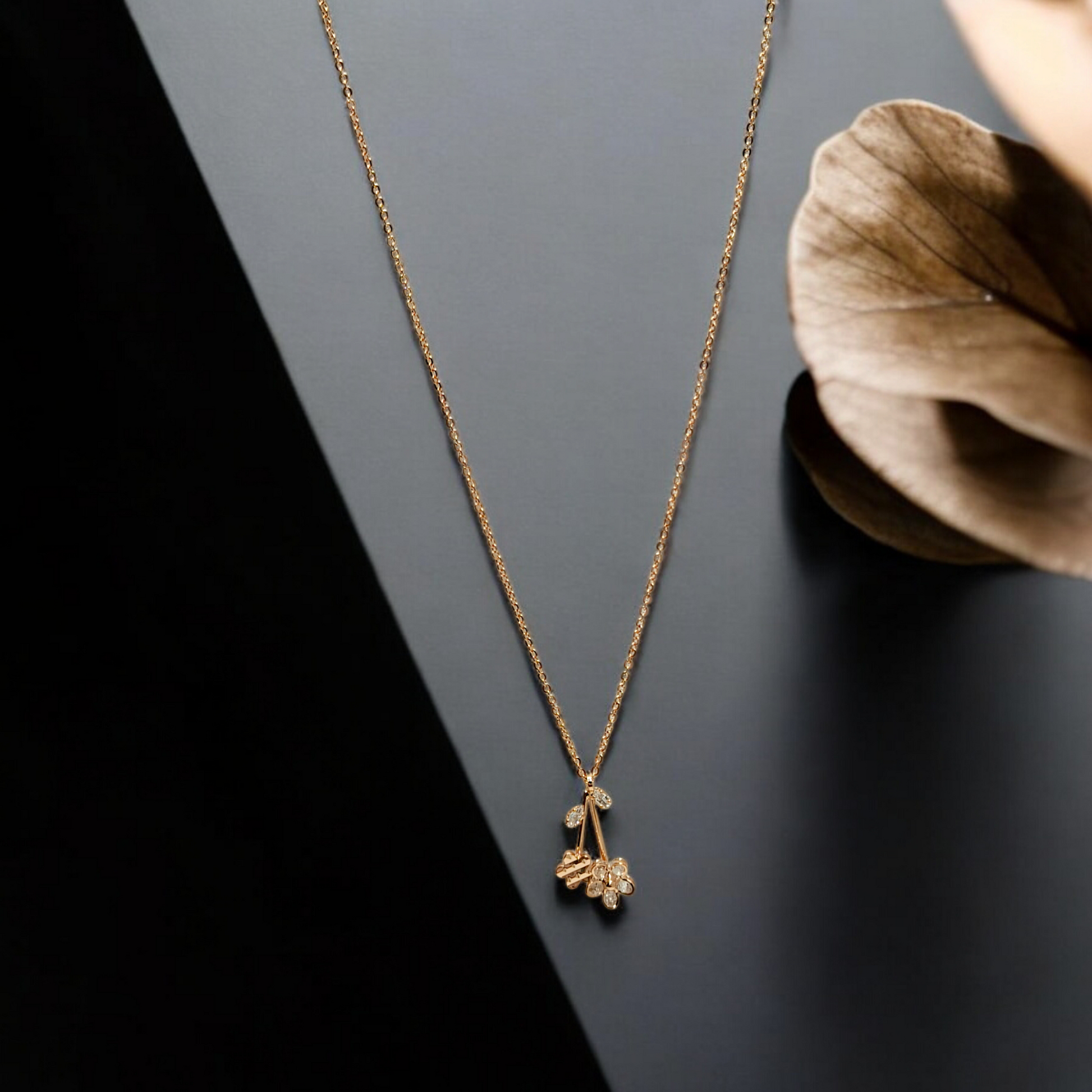 Gold necklace with a floral pendant on a dark surface