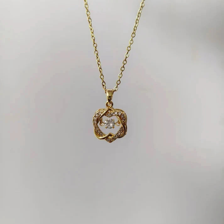 Gold necklace with a diamond pendant on a light gray background