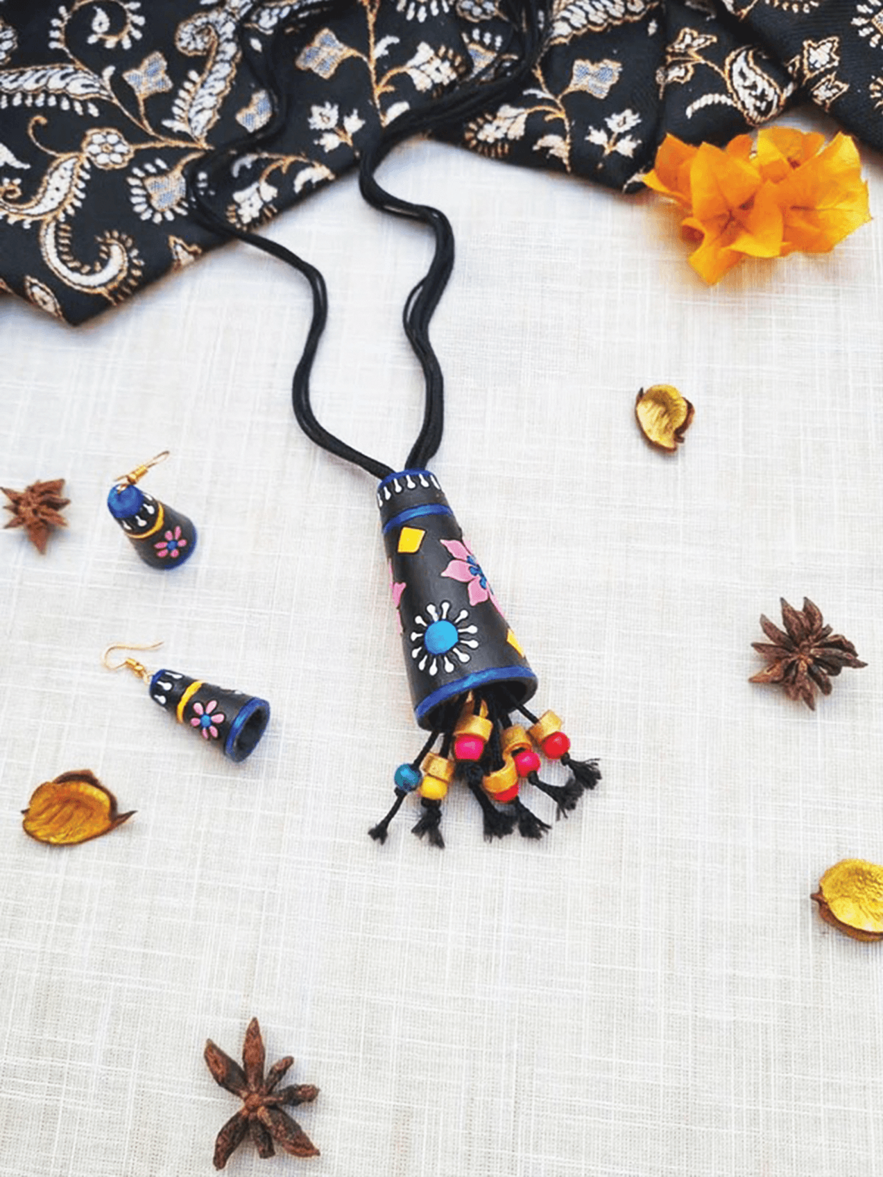 Affordable Handmade Cone Terracotta Pendant and Earring set with colorful floral designs on black background