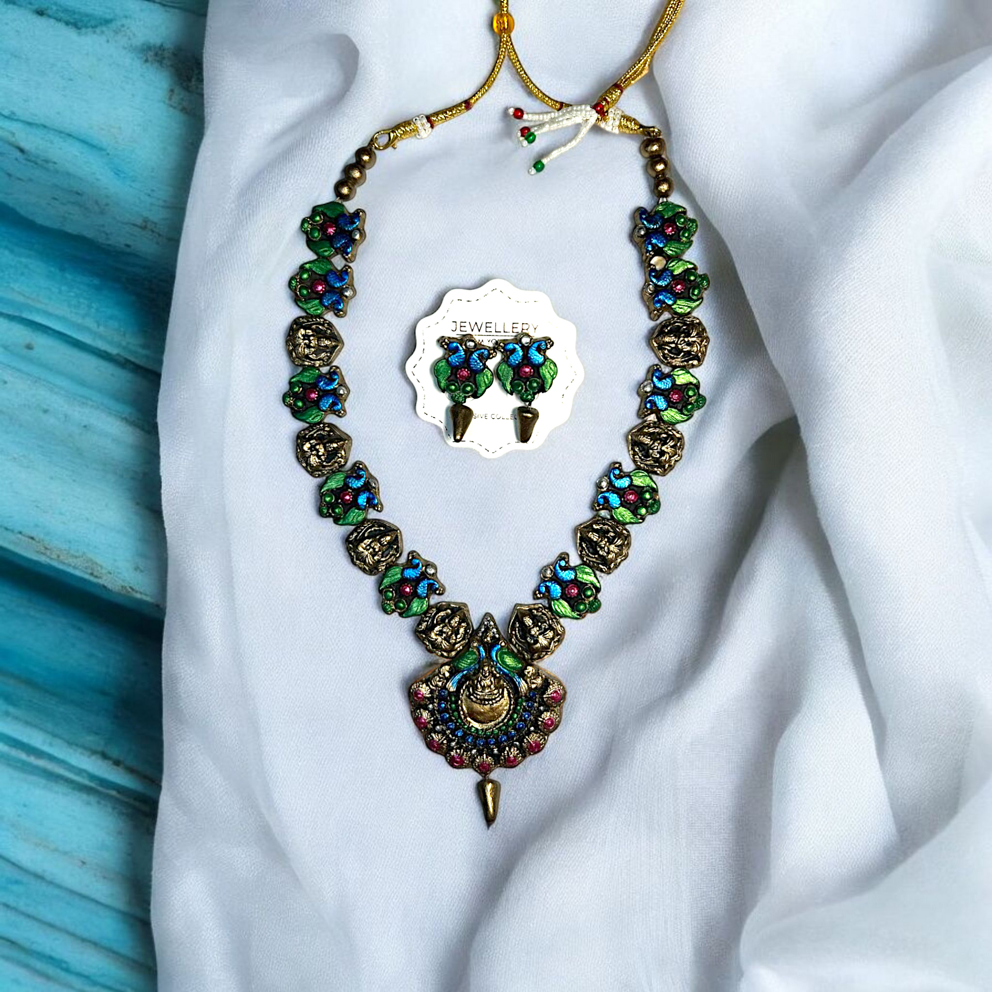 Handmade Artisan Peacock Charm Necklace and Earring Jewelry with colorful blue green and pink details from Mrritika